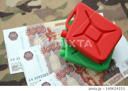 Petrol canister on russian roubles money bills on camouflage fabric. Concept of petroleum export Petrol canister on russian roubles money bills on camouflage fabric. Concept of petroleum export 140624353