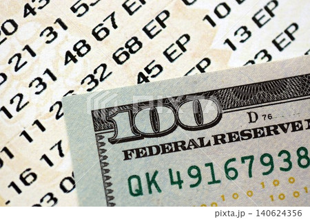 Lottery ticket and one hundred US dollar bill close up. Concept of gambling addiction 140624356