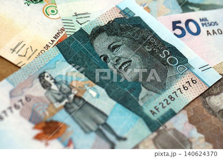 Colombian pesos money bills banknotes lies in big pile on table close up. Finances and business 140624370