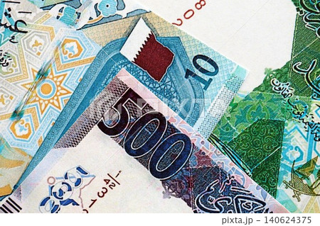 Qatari riyal money bills banknotes lies in big pile on table. Finances and business in Qatar 140624375