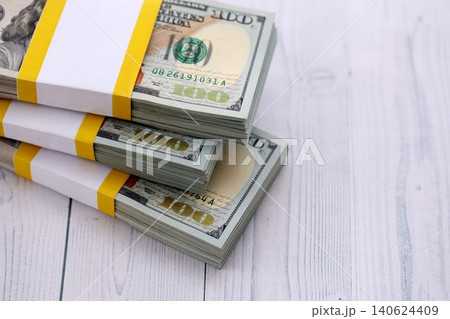 Three packs of ten thousand US dollar bills on wooden background. Packs of hundred dollar bills Three packs of ten thousand US dollar bills on wooden background. Packs of hundred dollar bills 140624409