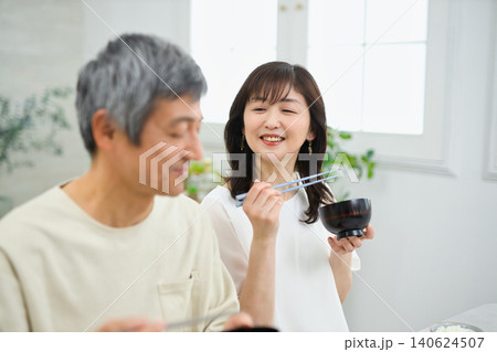 美味しそうに朝食を食べる60代の夫婦 美味しそうに朝食を食べる60代の夫婦 140624507