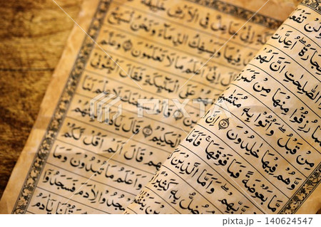 Pages of Al Quran Muslim old holy book on table in mosque. Details of arabic calligraphy in book 140624547