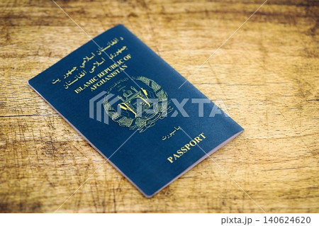 Afghan passport on table. Official identification document book for citizens of Afghanistan Afghan passport on table. Official identification document book for citizens of Afghanistan 140624620