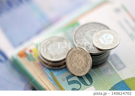Swiss franc money bills and cent coins pile on table. Switzerland coins on banknotes of CHF currency 140624702