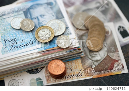 British pound money bills and penny coins pile. United Kingdom coins on banknotes of GBP currency 140624711