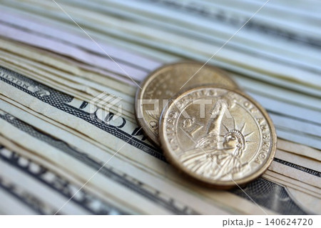 US dollar money bills and two dollar coins pile. United States coins on banknotes of USD currency US dollar money bills and two dollar coins pile. United States coins on banknotes of USD currency 140624720