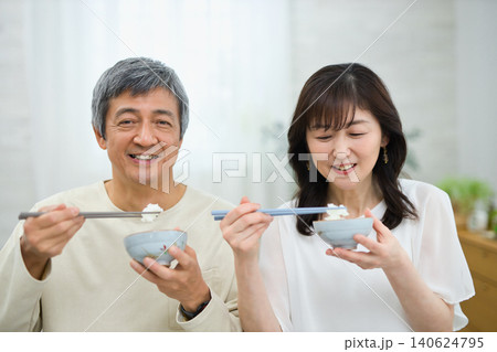 美味しそうに朝食を食べる60代の夫婦 美味しそうに朝食を食べる60代の夫婦 140624795