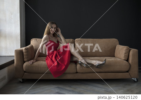 young beautiful woman sitting on a sofa near the window 140625120