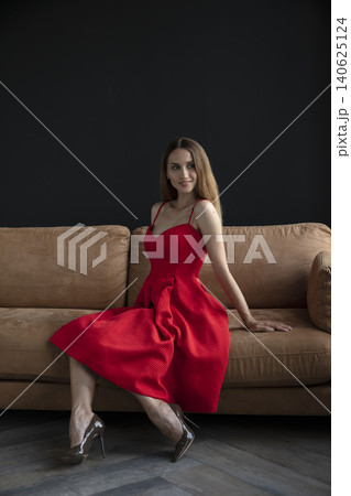 young beautiful woman sitting on a sofa near the window 140625124