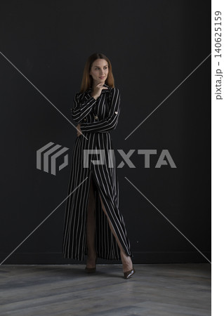 young beautiful woman on a dark background, full length studio shot young beautiful woman on a dark background, full length studio shot 140625159