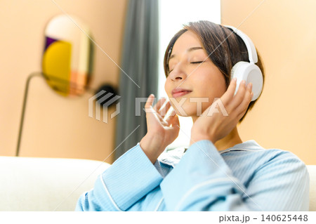 ヘッドホンで音楽に浸る若い女性 140625448
