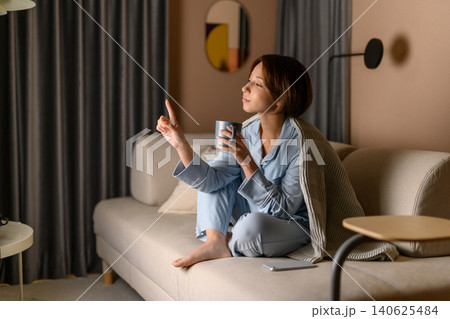 ソファでくつろぎながら飲み物を飲む女性 ソファでくつろぎながら飲み物を飲む女性 140625484