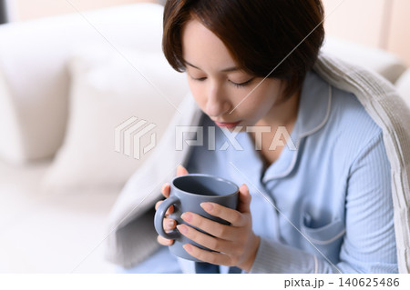 温かい飲み物を飲む女性 140625486