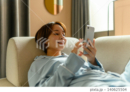 ソファでスマホを見る女性 ソファでスマホを見る女性 140625504