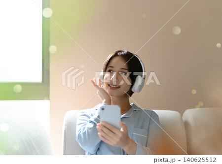 ヘッドホンで音楽を楽しむ若い女性 ヘッドホンで音楽を楽しむ若い女性 140625512
