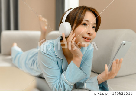 ヘッドホンで音楽を聴く若い女性 ヘッドホンで音楽を聴く若い女性 140625519