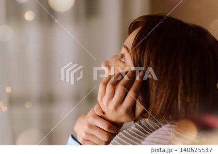 夜に窓辺で物思いにふける女性 140625537
