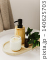 Still life of luxury spa essentials. A glass bottle with a serum, bottle with oil and candle on a table. 140625703