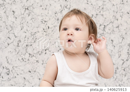 Happy laughing baby boy sitting shirtless on white bed and looking up Happy laughing baby boy sitting shirtless on white bed and looking up 140625913