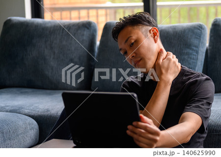 ソファでタブレットを見る男性 ソファでタブレットを見る男性 140625990