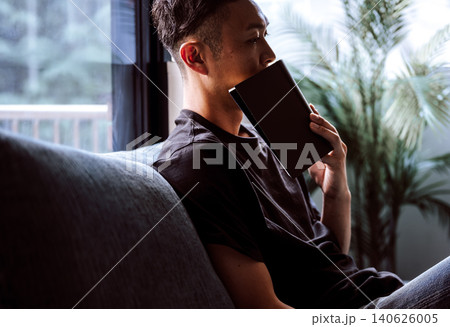 ソファで読書する男性 ソファで読書する男性 140626005
