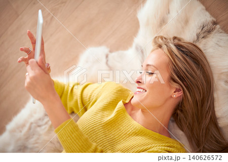 Tablet, smile and social media with woman on floor of home for browsing, communication or weekend free time. Tech, relax and happy young person in living room of apartment for download from above 140626572
