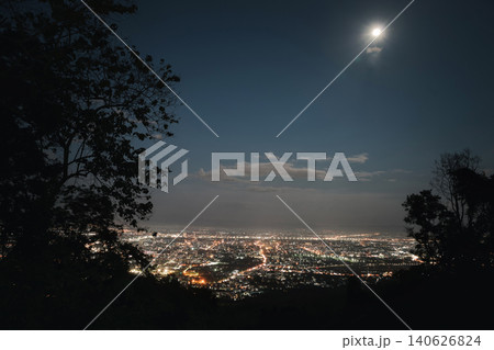 Top view of City night and moon light from the view point on top of mountain. Chiang Mai, Thailand. Aerial view, night city view with night sky. 140626824