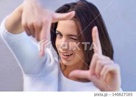 Happy woman, portrait and framing face with hands for photography, selfie or capture on a gray studio background. Young female person or model with smile or frame for picture moment, memory or photo Happy woman, portrait and framing face with hands for photography, selfie or capture on a gray studio background. Young female person or model with smile or frame for picture moment, memory or photo 140627165