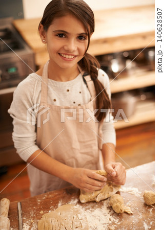 Girl, dough and baking portrait in kitchen, pastry and prepare flour mixture for cooking. Female person, kid and smile for learning in home, child development and education for cookie skill or cake Girl, dough and baking portrait in kitchen, pastry and prepare flour mixture for cooking. Female person, kid and smile for learning in home, child development and education for cookie skill or cake 140628507