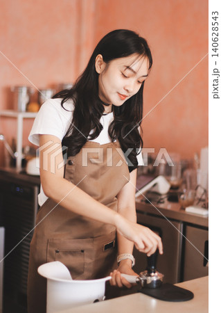 Young woman at barista school learning how to make espresso coffee. 140628543