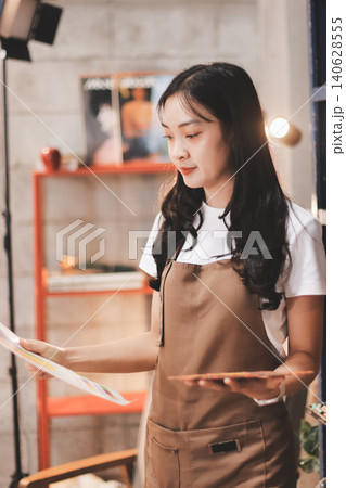 Female artist wears black hat posing near picture indoor the studio 140628555