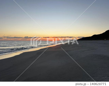 砂浜に打ち寄せる穏やかな波と沈みゆく夕日 砂浜に打ち寄せる穏やかな波と沈みゆく夕日 140628771