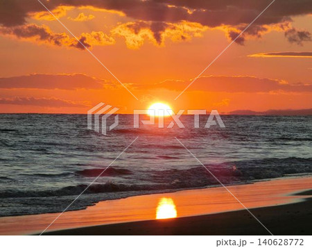 オレンジ色に染まる夕焼けと沈みゆく太陽 オレンジ色に染まる夕焼けと沈みゆく太陽 140628772