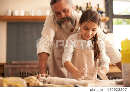 Girl, child and grandfather with dough in kitchen for cooking, baking and teaching with support or helping. Family, senior man and grandchild with cookies preparation in home for bonding and learning Girl, child and grandfather with dough in kitchen for cooking, baking and teaching with support or helping. Family, senior man and grandchild with cookies preparation in home for bonding and learning 140628807
