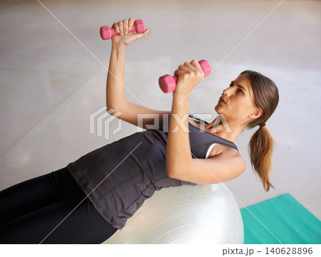 Exercise ball, home and woman with dumbbells, energy or cardio with balance or body with wellness. Health, person or athlete with equipment for training or weights for workout with challenge or power Exercise ball, home and woman with dumbbells, energy or cardio with balance or body with wellness. Health, person or athlete with equipment for training or weights for workout with challenge or power 140628896