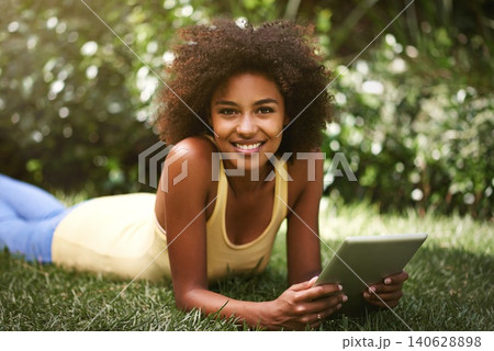 African woman, tablet and portrait on grass to relax, contact and smile for post on web blog. Girl, digital touchscreen and happy in backyard, garden and outdoor with app for social network in Brazil African woman, tablet and portrait on grass to relax, contact and smile for post on web blog. Girl, digital touchscreen and happy in backyard, garden and outdoor with app for social network in Brazil 140628898