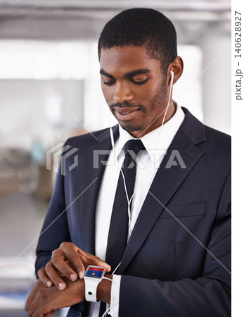 Office, earphones or businessman with smart watch for time technology or device for schedule. Black man, formal outfit or screen display network gadget for radio or music app, podcast or notification Office, earphones or businessman with smart watch for time technology or device for schedule. Black man, formal outfit or screen display network gadget for radio or music app, podcast or notification 140628927