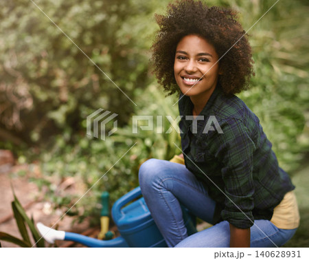 Woman, gardening and portrait with water can, plants and happy for spring, outdoor and earth. Girl, African person and smile on ground for growth, development and nature with ecology in backyard Woman, gardening and portrait with water can, plants and happy for spring, outdoor and earth. Girl, African person and smile on ground for growth, development and nature with ecology in backyard 140628931
