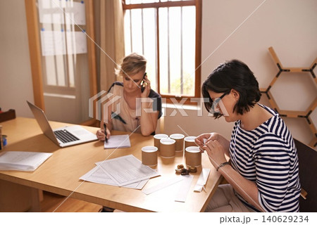 Teamwork, phone call and online order with business women in office together for planning or strategy. Collaboration, laptop and candle maker people in creative startup for design or communication Teamwork, phone call and online order with business women in office together for planning or strategy. Collaboration, laptop and candle maker people in creative startup for design or communication 140629234