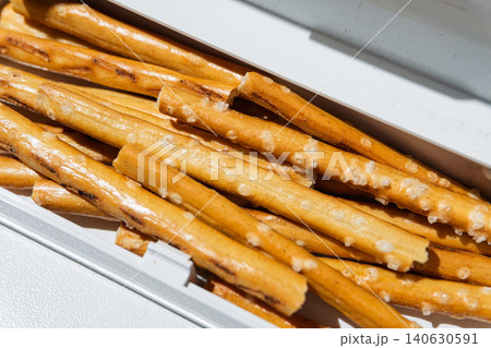 Salty pretzel sticks inside a white plastic container tray Salty pretzel sticks inside a white plastic container tray 140630591