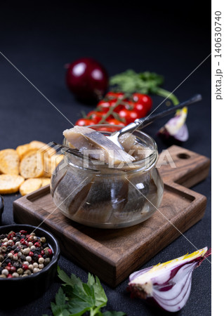 Pickled herring fillet in glass jar with fork Pickled herring fillet in glass jar with fork 140630740