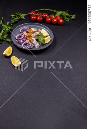 Pickled herring fillet appetizers with red onion and lemon 140630755
