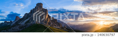 Dramatic sunset panorama of Ra Gusela at Passo Giau in the Italian Dolomites. Rugged limestone cliffs, golden sun rays and breathtaking alpine scenery under colorful clouds. Dramatic sunset panorama of Ra Gusela at Passo Giau in the Italian Dolomites. Rugged limestone cliffs, golden sun rays and breathtaking alpine scenery under colorful clouds. 140630797