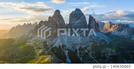 Panoramic view of Tre Cime di Lavaredo glowing in golden sunset light in the Italian Dolomites. Dramatic alpine landscape with rugged peaks, winding trails and breathtaking scenery. Panoramic view of Tre Cime di Lavaredo glowing in golden sunset light in the Italian Dolomites. Dramatic alpine landscape with rugged peaks, winding trails and breathtaking scenery. 140630803
