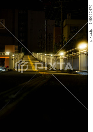 規則的な照明と点字ブロックが奥へ続く静かな夜の歩道橋 140632476
