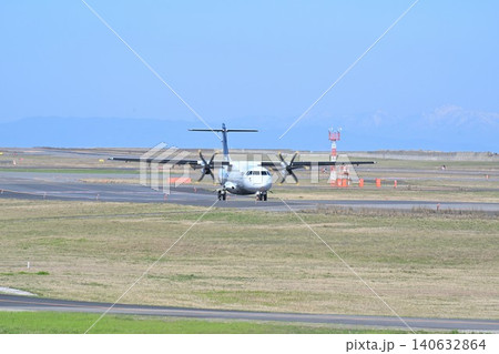 新潟空港の滑走路を走行するプロペラ機（新潟県新潟市東区） 140632864