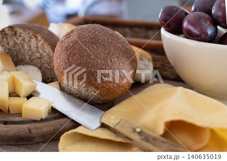 Knife on wooden table with cheese and cut breads 140635019