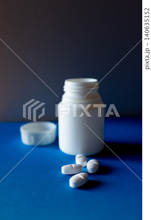 White capsules with packaging on blue background. Health care concept White capsules with packaging on blue background. Health care concept 140635152