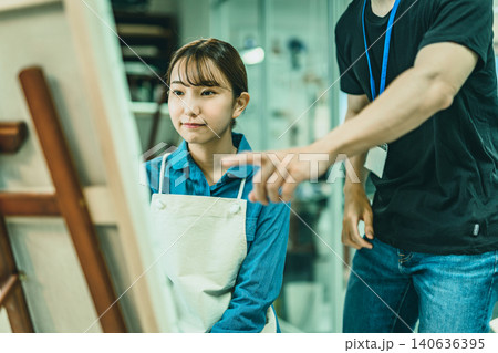 絵画教室で指導を受ける若い女性 140636395